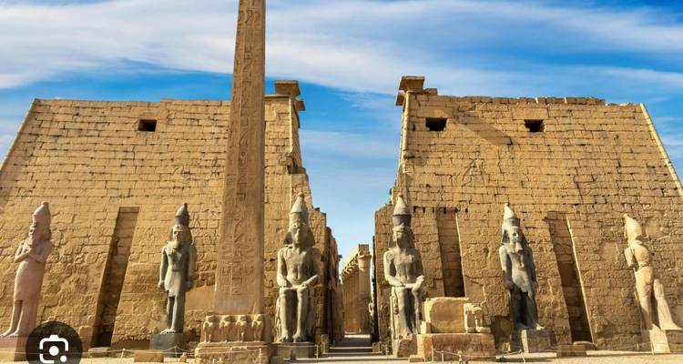 Gran entrada del Templo de Luxor con obelisco y estatuas sedentes bajo cielo azul