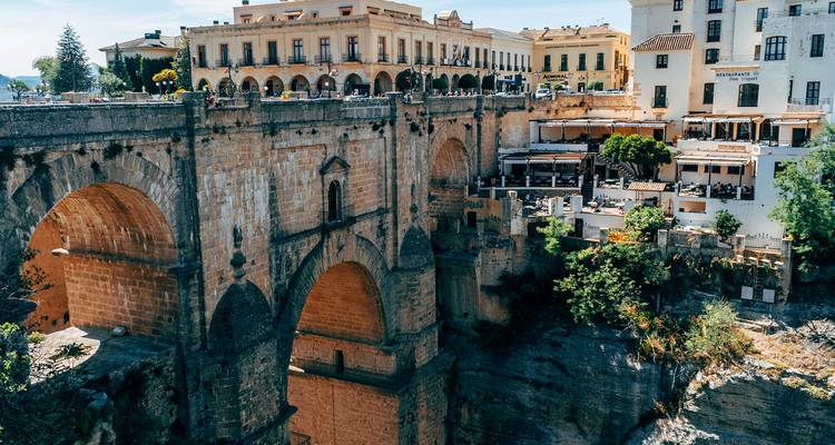 Die dramatische steinerne Puente Nuevo Brücke und Restaurants an der Klippe mit Blick auf die Schlucht in Ronda