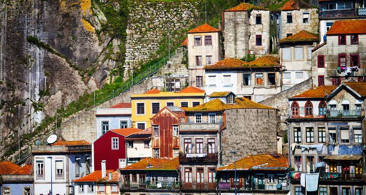 Vista cercana de casas coloridas en la ladera y muros de piedra en Oporto.