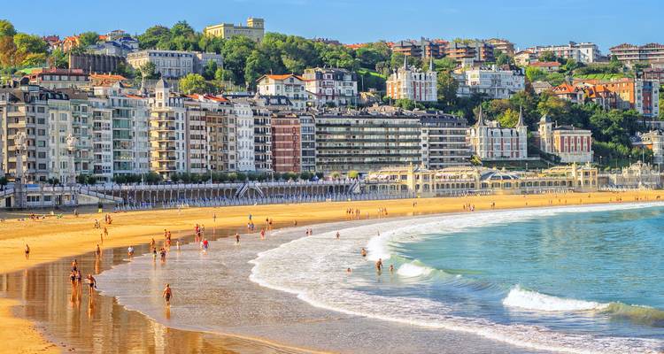 Le sable doré de la plage de La Concha s'arque sous les élégants bâtiments en bord de mer et les collines vertes de Saint-Sébastien.