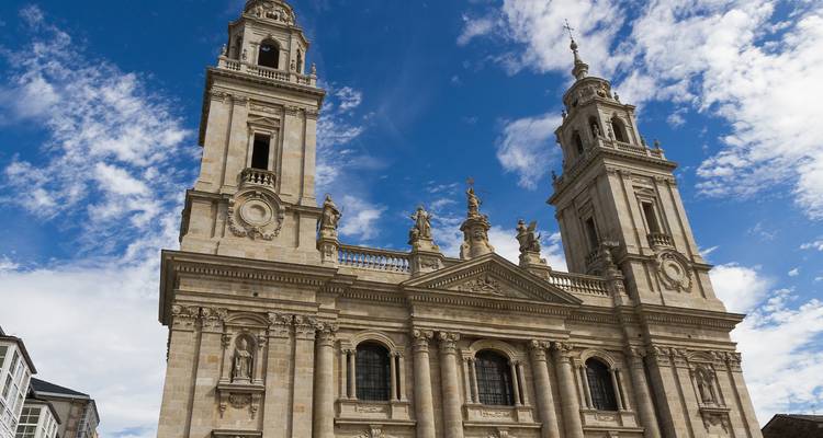 La façade baroque à tours jumelles de la cathédrale de Lugo s'élève dans un ciel bleu éclatant.
