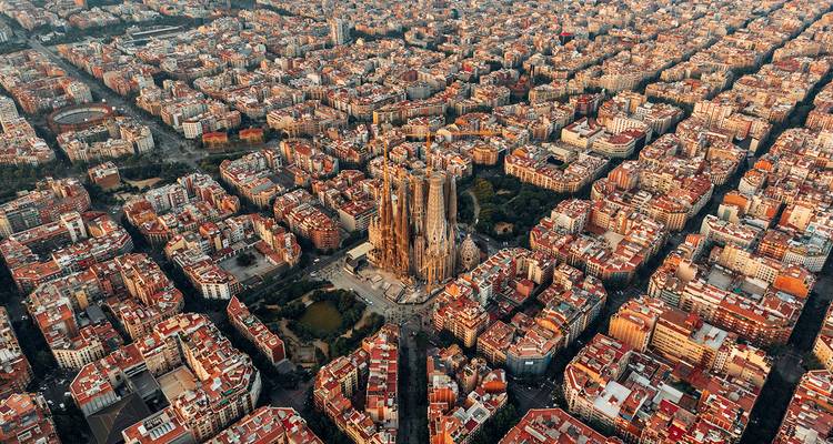 Vue aérienne spectaculaire du quadrillage urbain de Barcelone centré sur les flèches élancées de la Sagrada Família.