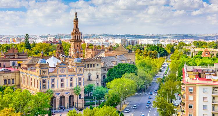 Panoramic view of Seville’s Plaza de España tower rising above tree-lined avenues.