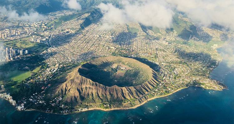 Panorama aérien d'Honolulu encadrant le célèbre cratère de Diamond Head et le paysage urbain tentaculaire au bord de la mer.