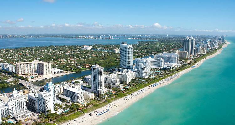 Luftpanorama von Miami Beach mit türkisfarbenem Wasser, weißem Sandstrand und moderner Hochhaus-Skyline.
