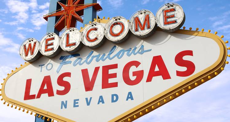 Primer plano del icónico letrero de neón 'Welcome to Fabulous Las Vegas' contra el cielo azul.