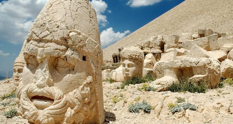 Verwitterte riesige Steinköpfe stehen auf dem Berg Nemrut unter einem strahlend blauen Himmel.