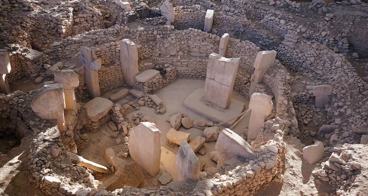Alte kreisförmige Steineinfriedungen der archäologischen Stätte Göbekli Tepe unter sanftem Licht.