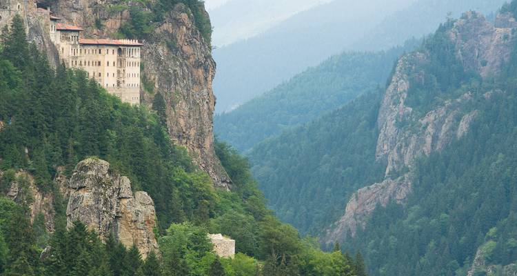 Das Sumela-Kloster klammert sich an eine steile bewaldete Klippe hoch über einem nebligen Tal im Pontischen Gebirge.