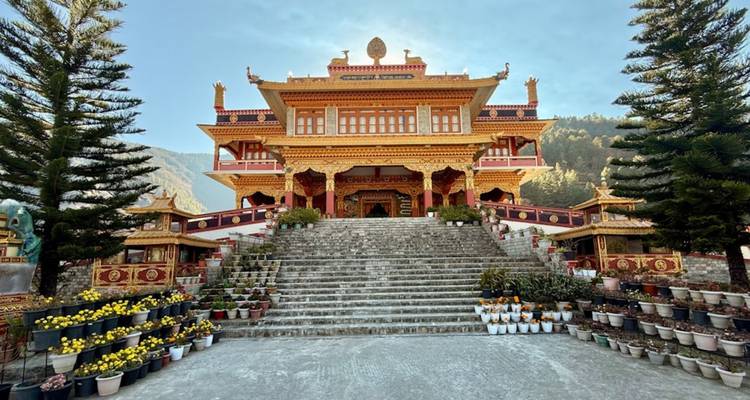 Brightly painted hilltop monastery reached by wide stone steps and potted flowers