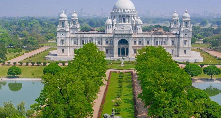 Grand white marble Victoria Memorial and manicured gardens seen from above.