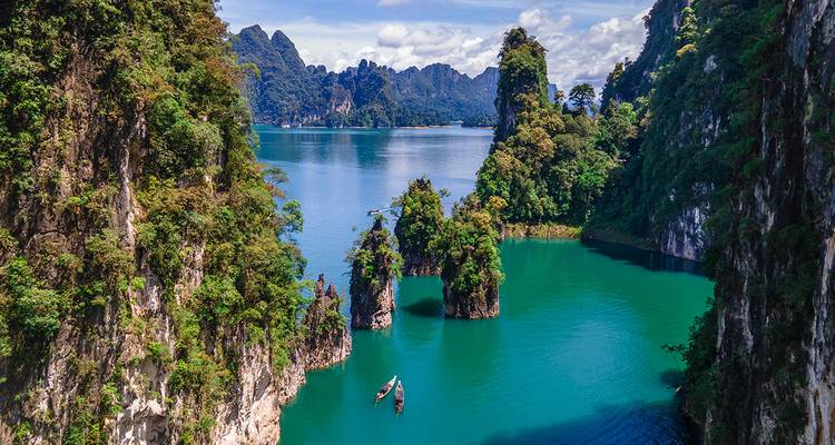 Lac turquoise spectaculaire entouré de falaises calcaires karstiques imposantes et de jungle luxuriante dans le parc national de Khao Sok.