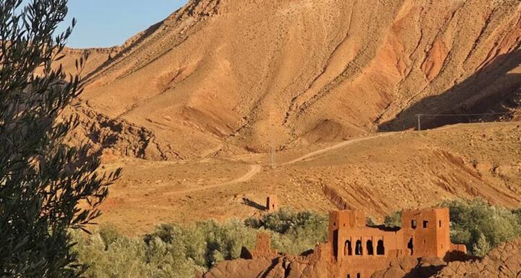Las estructuras de adobe en ruinas se encuentran bajo colinas áridas en el campo marroquí.