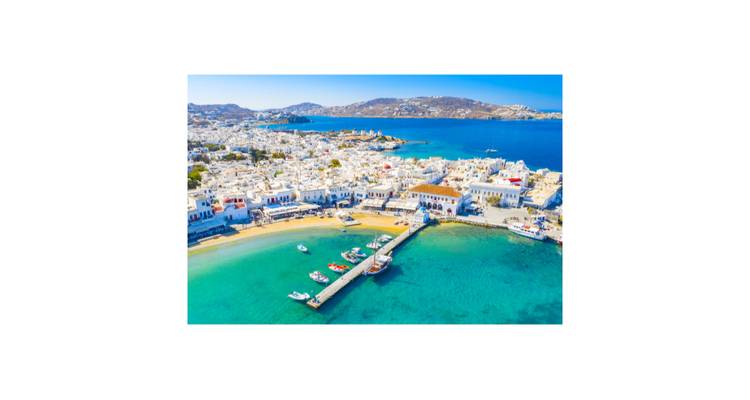 Vista aérea de la ciudad de Mykonos y las aguas turquesas del puerto bajo el brillante sol del mediodía, presentada con márgenes blancos.