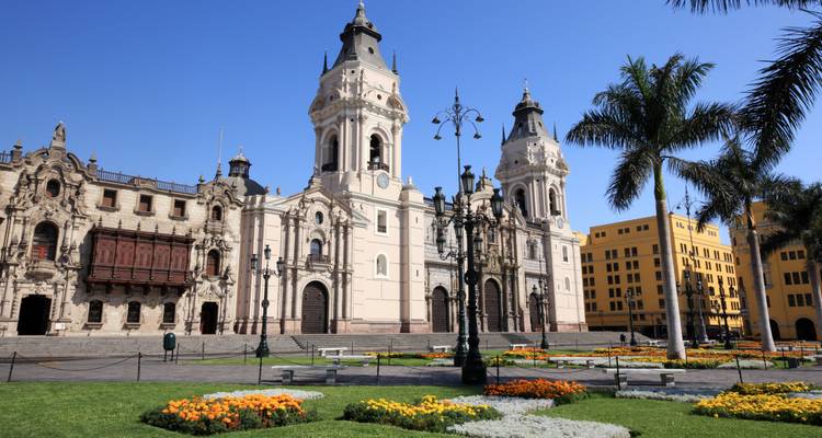 Sonniger Plaza Mayor mit der Kathedrale von Lima, Palmen und bunten Blumenbeeten