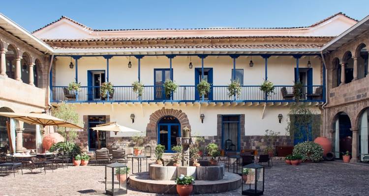 Charmantes koloniales Innenhofhotel mit blauen Balkonen, Topfpflanzen und zentralem Springbrunnen