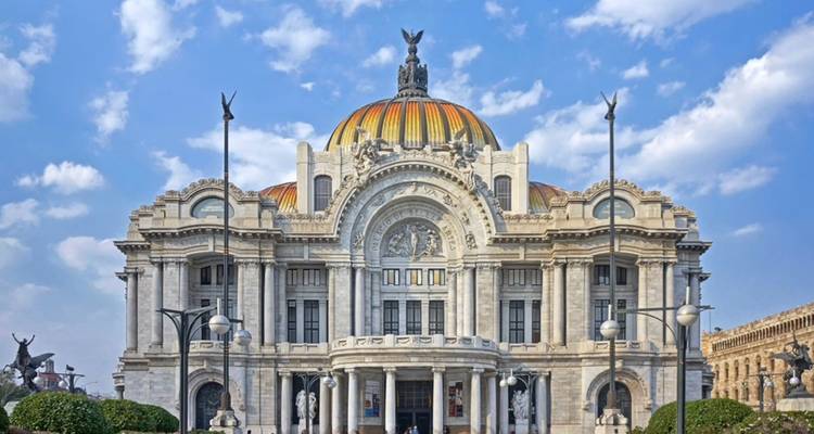 Het sierlijke Palacio de Bellas Artes glanst onder een heldere blauwe hemel met wolken in Mexico-Stad.