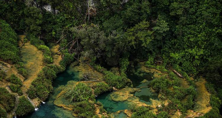 Turquoise trapsgewijze poelen en weelderige jungle kenmerken de natuurlijke terrassen van Semuc Champey.