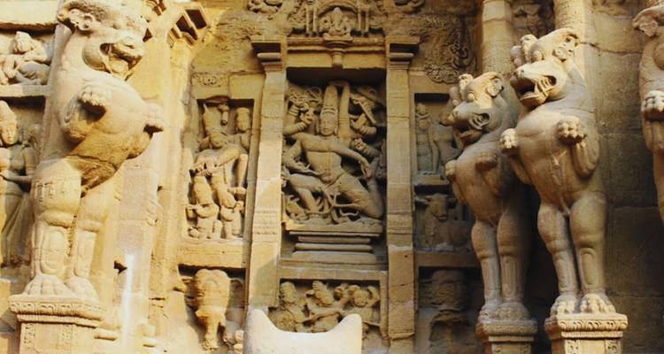 Intricate stone reliefs of mythical creatures and deities inside a rock-cut temple at Mahabalipuram.
