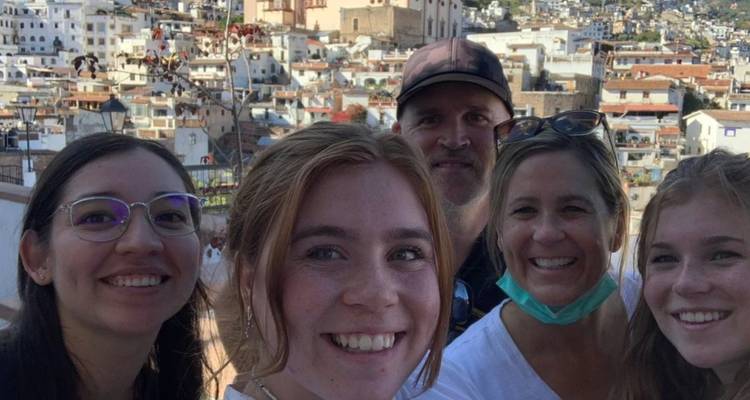 Lächelndes Gruppen-Selfie mit einem Panoramablick auf die weiß getünchte Hügelstadt Taxco im Hintergrund