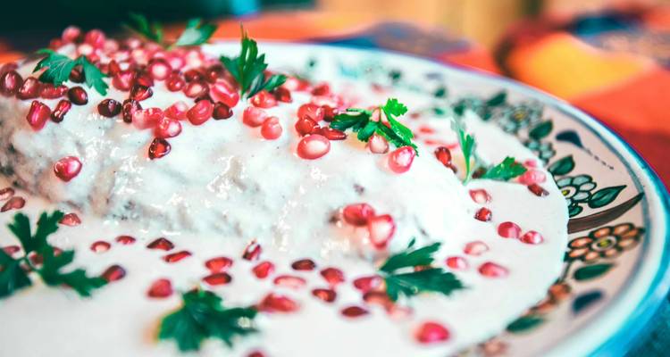 Traditionelles Puebla-Gericht Chile en Nogada garniert mit Granatapfelkernen und Petersilie