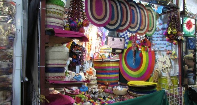 Puesto de mercado vibrante rebosante de cestas tejidas, sombreros y artesanías coloridas.