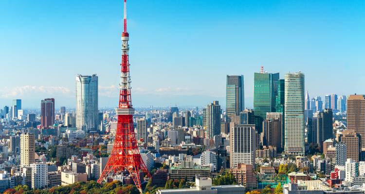 Tokyo’s skyline dominated by the red Tokyo Tower rises against a crystal clear blue sky.