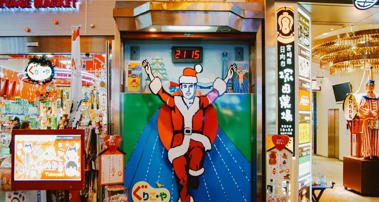 Colorful arcade machine featuring Santa-clad running mascot inside lively Japanese market hall.