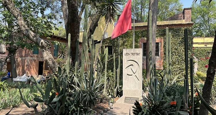 Jardín en el Museo de León Trotsky con plantas de cactus y una piedra conmemorativa