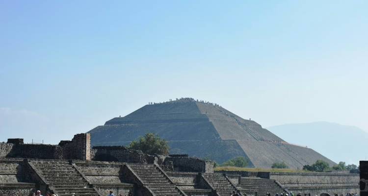 Entfernte verschwommene Sicht auf die Sonnenpyramide, die sich über antike Steinplattformen erhebt.