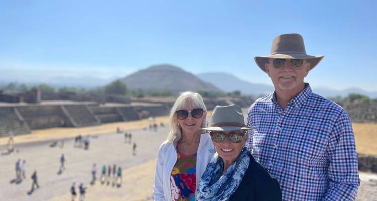 Ältere und jüngere Familienmitglieder lächeln mit der Teotihuacán-Stätte im Hintergrund.