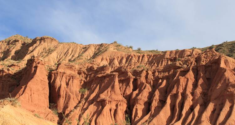 Impresionantes formaciones y crestas de arenisca roja bajo un cielo azul despejado.