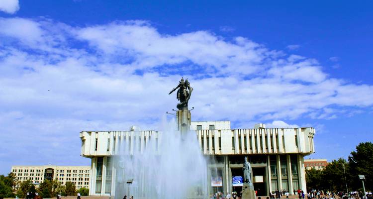 Gran fuente brotando frente al edificio gubernamental de la era soviética en la Plaza Ala-Too en Bishkek.