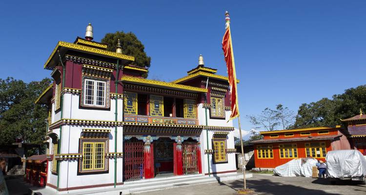 Colorful Buddhist monastery with intricate woodwork under clear blue sky