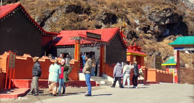 Tourists gathered outside a brightly painted building in a mountainous pass