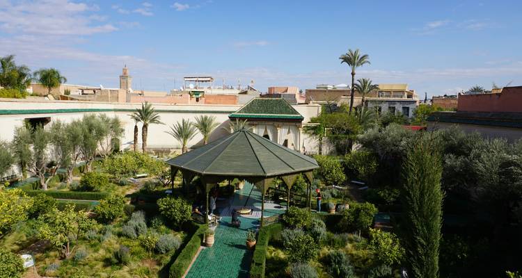 Üppiger Innenhofgarten mit grün gefliesten Pavillon im Komplex des Marrakech Secret Garden.