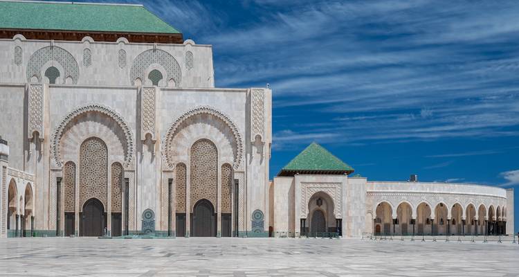 Sección lateral de la Mezquita Hassan II mostrando grandes puertas ornamentadas y techos con azulejos verdes