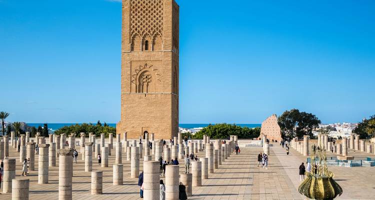 Plaza de la Torre de Hassan con columnas de piedra extendiéndose hacia el océano en un día soleado