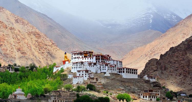 Großer buddhistischer Klosterkomplex eingebettet zwischen kargen Bergen unter einem dunsigen Himmel