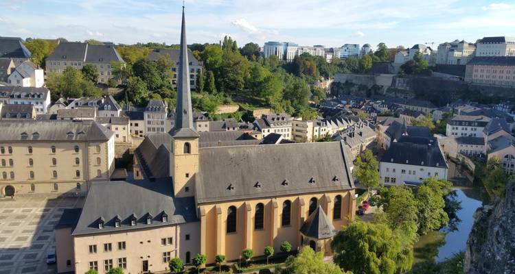 Vue panoramique de la vieille ville de Luxembourg avec le clocher de l'église, les ponts de pierre et les falaises.