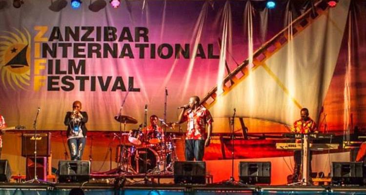 Los músicos actúan en un escenario brillantemente iluminado bajo la pancarta del Festival Internacional de Cine de Zanzíbar.