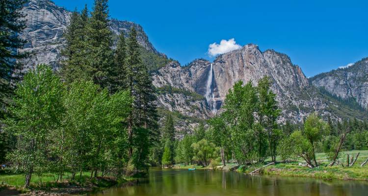 Día despejado de verano en el río Merced con acantilados de granito y una cascada en Yosemite.