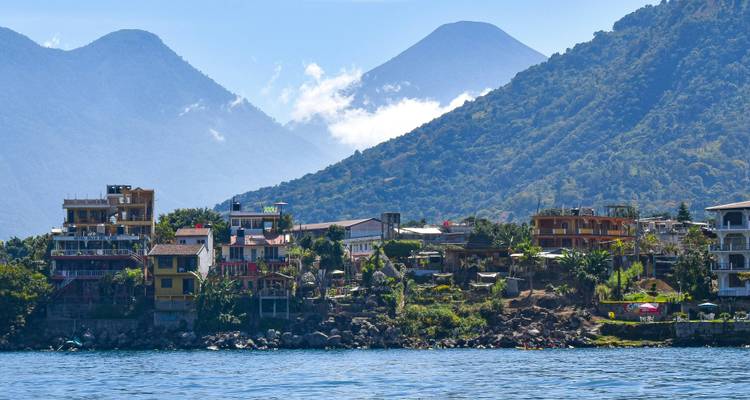 Village coloré au bord du lac adossé à des volcans boisés s'élevant au-dessus du lac bleu Atitlán