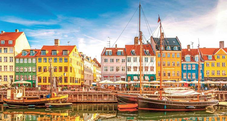 Kleurrijke historische huizen en houten boten langs het Nyhavn-kanaal in Kopenhagen op een heldere dag.