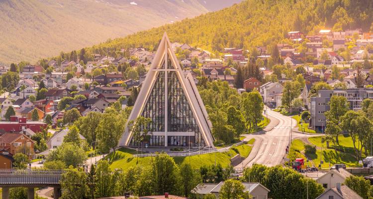 La Cathédrale arctique ensoleillée s'élève au milieu de maisons colorées et de collines boisées à Tromsø.