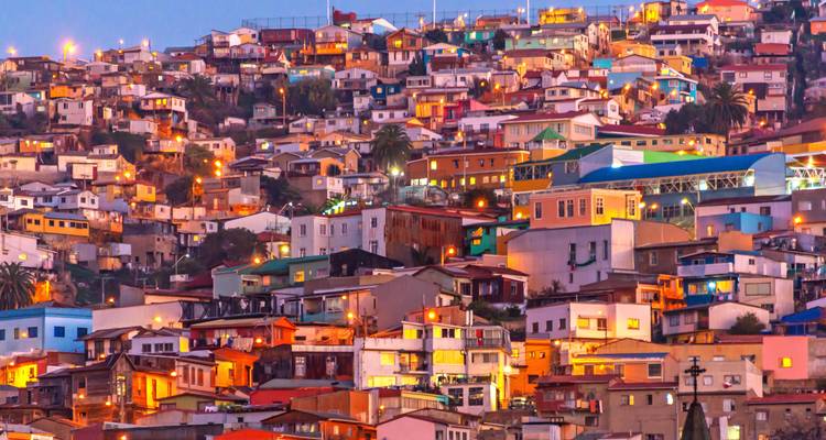 Bunte Hanghäuser von Valparaíso, die in der Dämmerung mit unzähligen warmen Lichtern beleuchtet sind.
