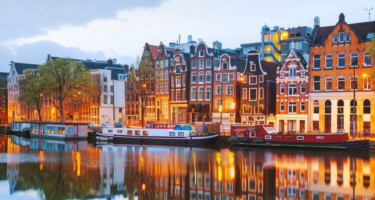 Les pittoresques maisons de canal d'Amsterdam se reflétant dans les eaux calmes à la tombée du jour.
