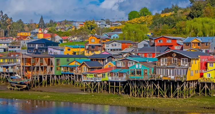 Rangée de maisons colorées en bois sur pilotis bordant le front de mer des marées de Castro sur l'île de Chiloé.