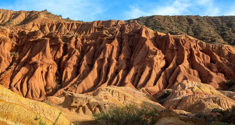 Lebendige rote und gelbe erodierte Formationen des Märchencanyons unter blauem Himmel.