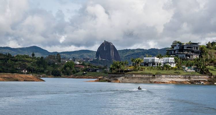 Uitzicht over het reservoir richting El Peñol rots en moderne huizen bij Guatapé.